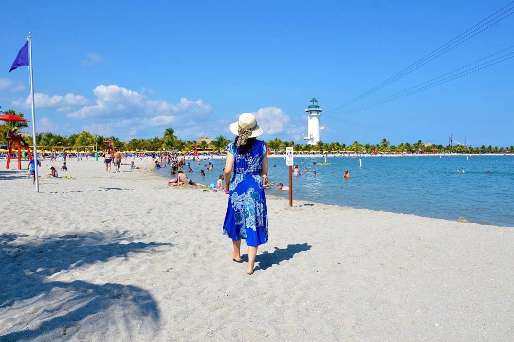 Woman enjoys sunshine and sand in Harvest Caye